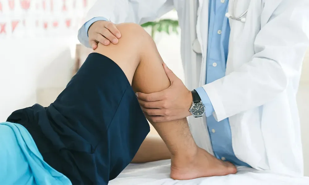 Provider examining an athlete's knee during a sports physical at Magnolia Medical Group